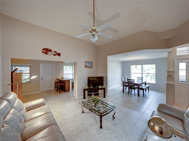 tiled living room with ceiling fan and lofted ceiling