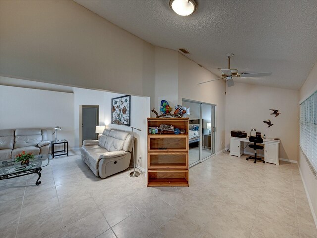 tiled living room featuring ceiling fan, high vaulted ceiling, and a textured ceiling