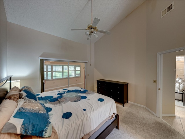 bedroom with a textured ceiling, ceiling fan, light carpet, and high vaulted ceiling