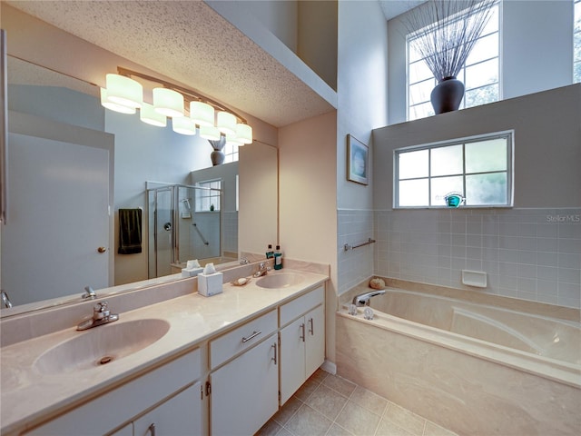 bathroom featuring tile patterned flooring, vanity, separate shower and tub, and a textured ceiling