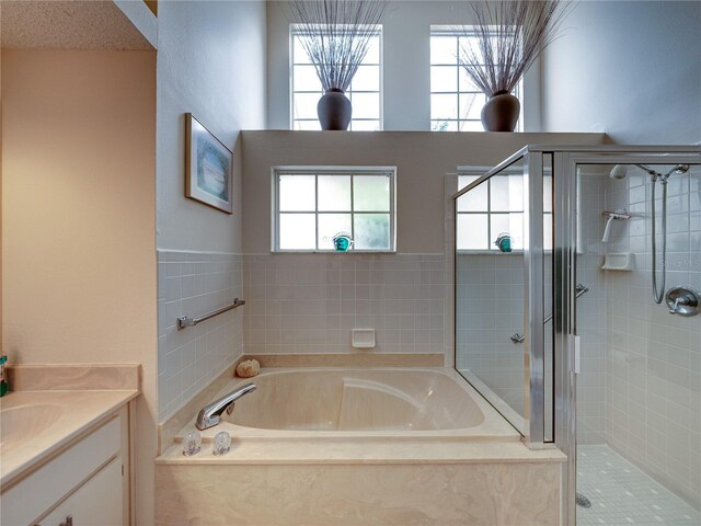 bathroom featuring vanity, a textured ceiling, and independent shower and bath