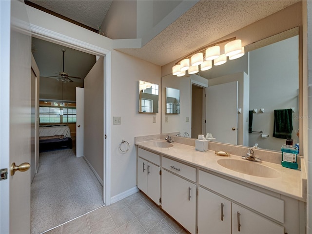 bathroom with tile patterned flooring, vanity, ceiling fan, and a textured ceiling