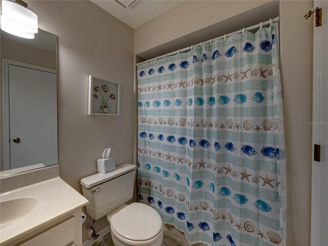 bathroom featuring vanity, curtained shower, toilet, and a textured ceiling