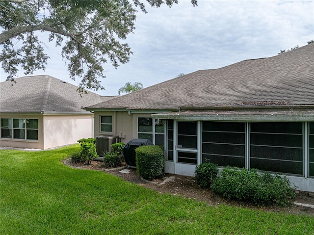 rear view of property with a yard and central AC unit