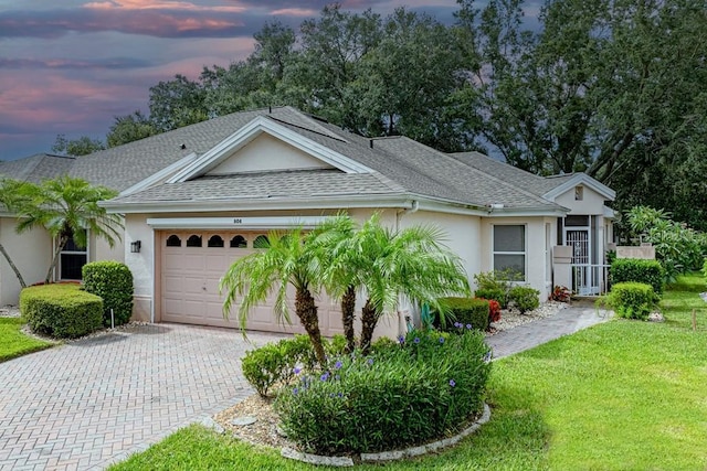 ranch-style house featuring a yard and a garage