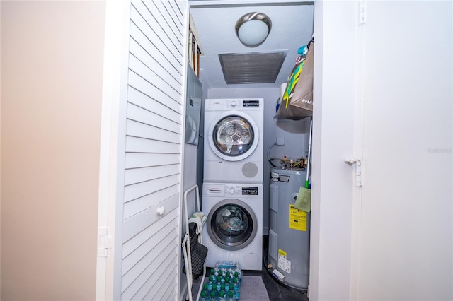 washroom with electric water heater and stacked washer and dryer