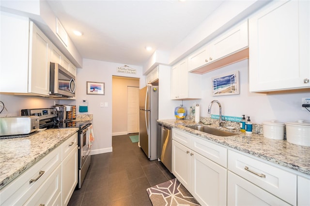 kitchen featuring sink, appliances with stainless steel finishes, white cabinets, and dark tile patterned flooring