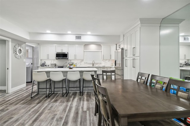 dining space with hardwood / wood-style flooring and sink