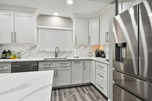 kitchen featuring white cabinetry, backsplash, light stone counters, and stainless steel appliances