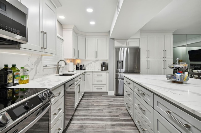 kitchen featuring light stone countertops, appliances with stainless steel finishes, sink, and white cabinets