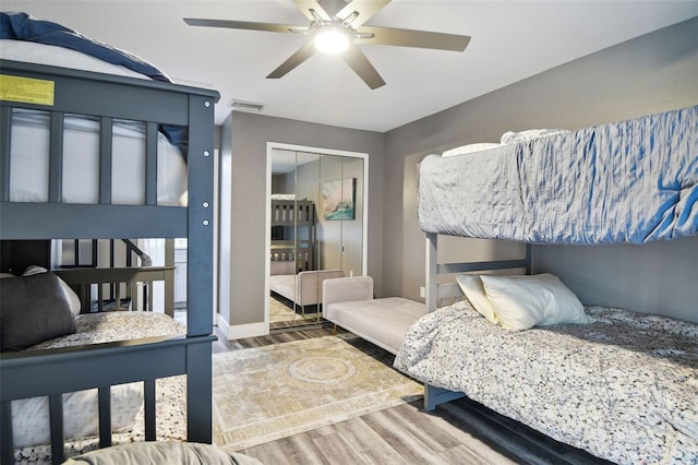 bedroom with wood-type flooring, a closet, and ceiling fan