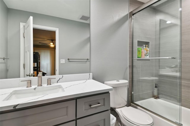 full bathroom featuring enclosed tub / shower combo, vanity, and toilet