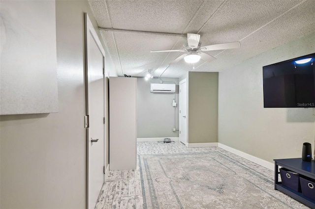 interior space with an AC wall unit and ceiling fan