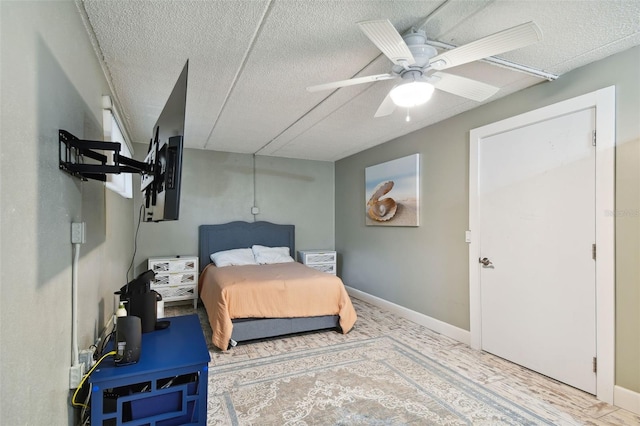 bedroom with ceiling fan and a textured ceiling