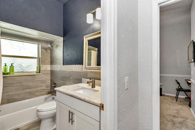 full bathroom featuring vanity, tiled shower / bath, and toilet