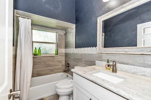 full bathroom with tile walls, shower / bath combo, toilet, and vanity