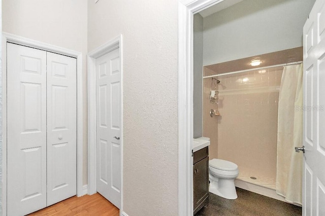 bathroom with vanity, a shower with shower curtain, hardwood / wood-style flooring, and toilet