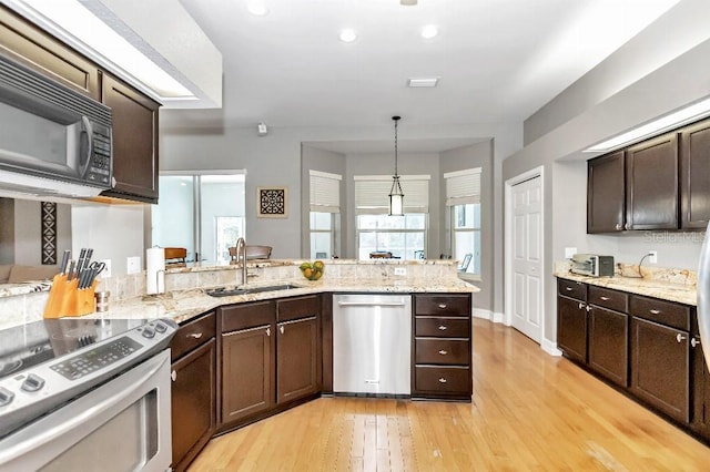 kitchen featuring light hardwood / wood-style flooring, range with electric cooktop, sink, decorative light fixtures, and stainless steel dishwasher