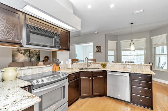 kitchen featuring appliances with stainless steel finishes, kitchen peninsula, light wood-type flooring, and dark brown cabinetry