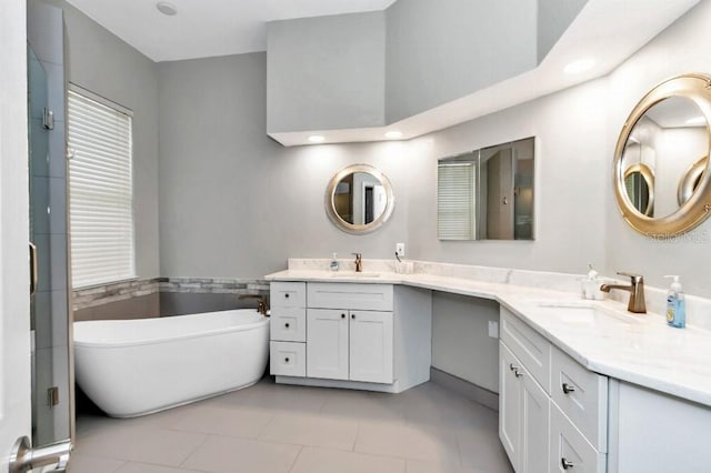 bathroom with a tub, tile patterned floors, and double vanity