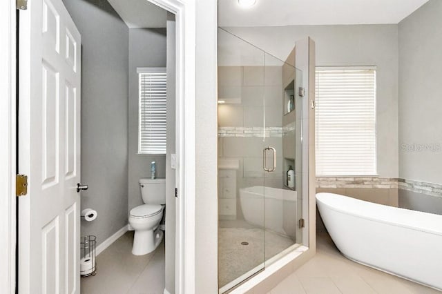 bathroom featuring toilet, tile patterned floors, and separate shower and tub