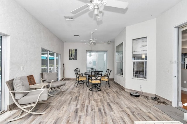 dining space with light hardwood / wood-style floors and ceiling fan