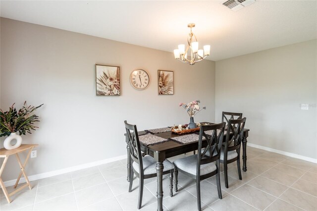 tiled dining room featuring a chandelier