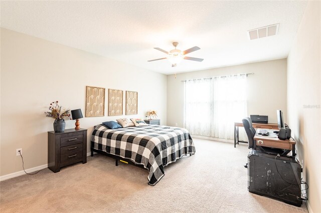 bedroom with ceiling fan and light carpet