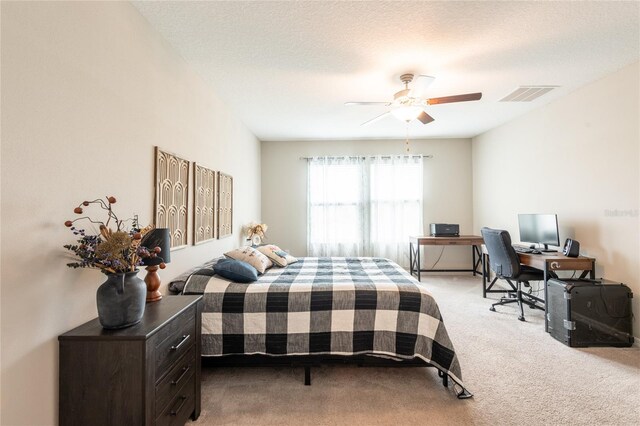 bedroom with ceiling fan, a textured ceiling, and light carpet