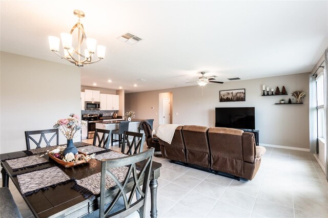 dining space featuring ceiling fan with notable chandelier and light tile patterned floors