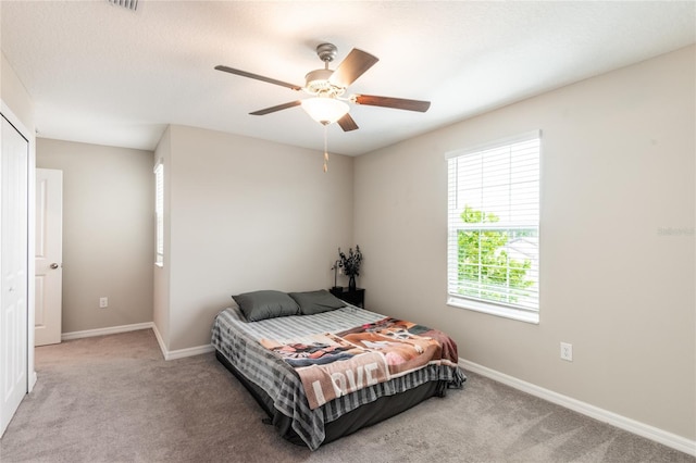 carpeted bedroom featuring ceiling fan and a textured ceiling