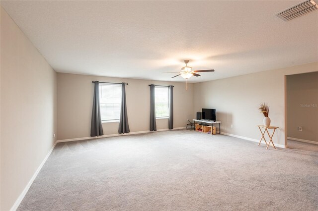 unfurnished living room featuring a textured ceiling, carpet flooring, and ceiling fan