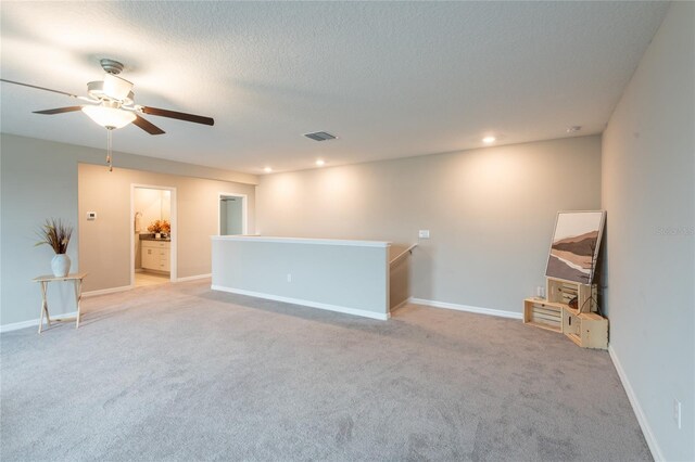 unfurnished room featuring ceiling fan, a textured ceiling, and light colored carpet