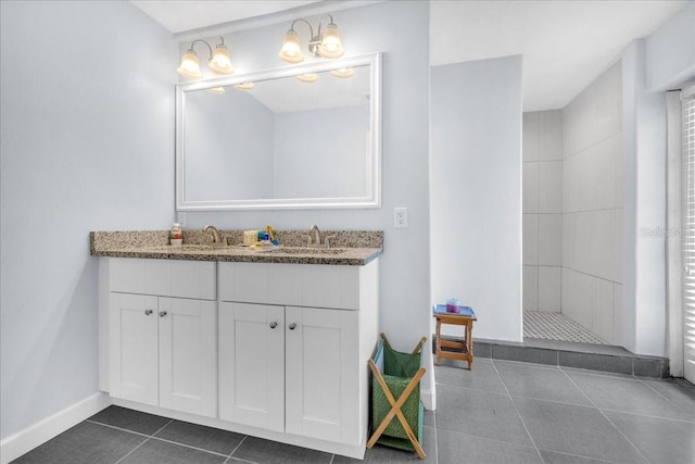 bathroom featuring a tile shower, tile patterned flooring, vanity, and a notable chandelier