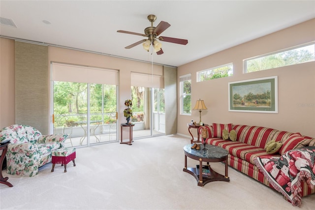 living room with ceiling fan, carpet flooring, and a wealth of natural light