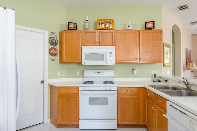 kitchen with white appliances, sink, and light tile patterned floors