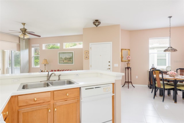 kitchen featuring ceiling fan, white dishwasher, sink, and hanging light fixtures