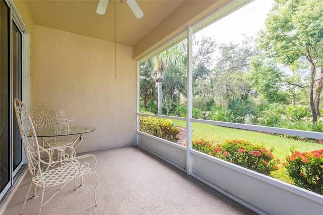 unfurnished sunroom with ceiling fan