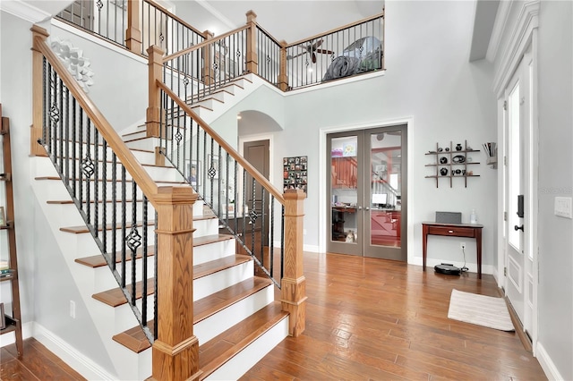 entrance foyer featuring a wealth of natural light, a towering ceiling, hardwood / wood-style floors, and french doors