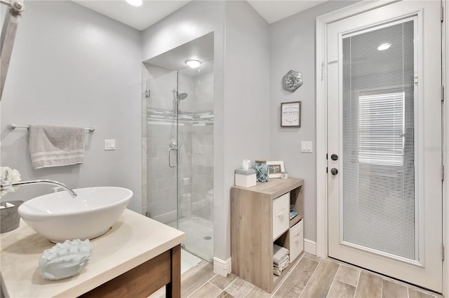 bathroom featuring vanity and a shower with door