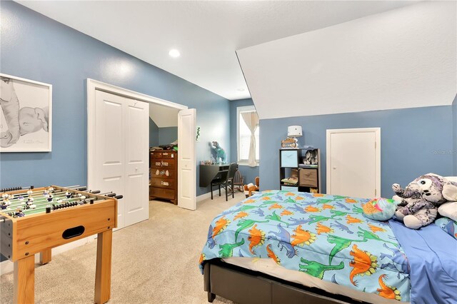 carpeted bedroom with a closet and lofted ceiling