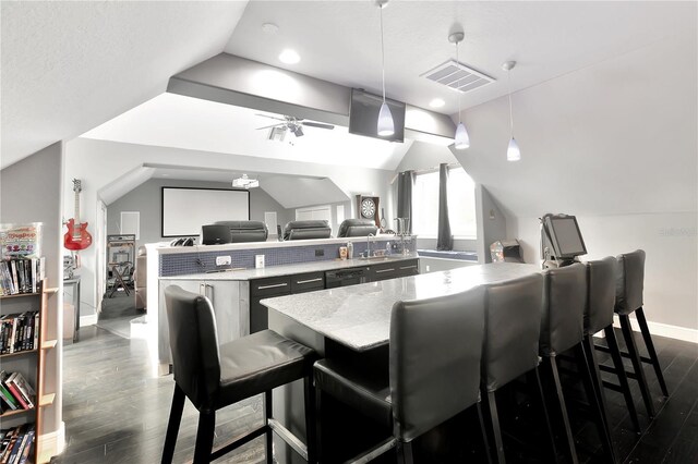 kitchen with dark hardwood / wood-style flooring, hanging light fixtures, a kitchen bar, and ceiling fan