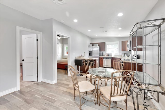 dining room with ceiling fan and light wood-type flooring