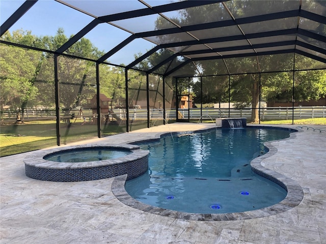 view of pool featuring a patio, an in ground hot tub, pool water feature, and glass enclosure