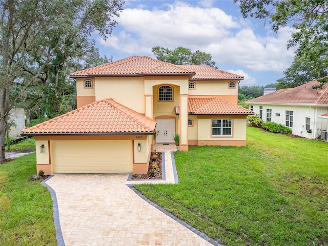 mediterranean / spanish house featuring a garage and a front lawn