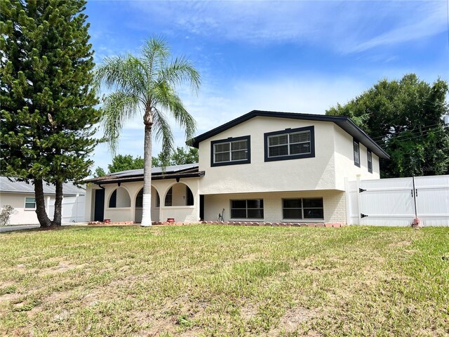 rear view of property with a lawn