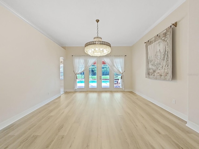 unfurnished dining area featuring light hardwood / wood-style floors, an inviting chandelier, french doors, and ornamental molding