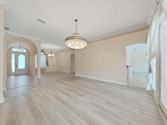 interior space featuring light wood-type flooring, crown molding, and a notable chandelier