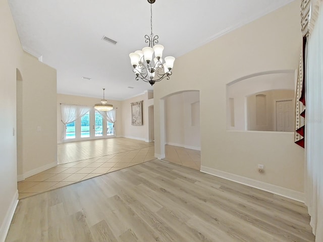 unfurnished room with light hardwood / wood-style flooring, a chandelier, and ornamental molding