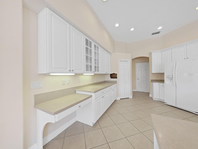 kitchen with light tile patterned flooring, white cabinetry, and white fridge with ice dispenser